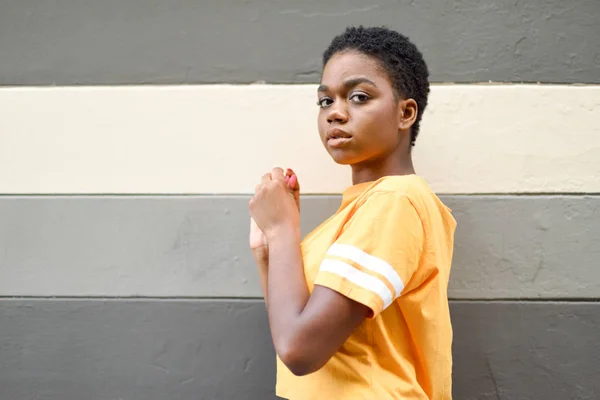 Ung svart kvinna med allvarliga uttryck tittar på kamera. — Stockfoto