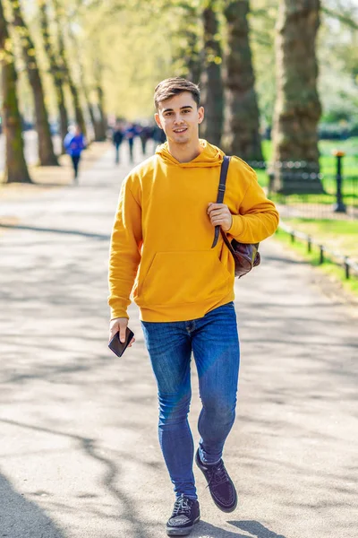 Ung Urban man med smartphone Walking in Street i en Urban Park i London. — Stockfoto