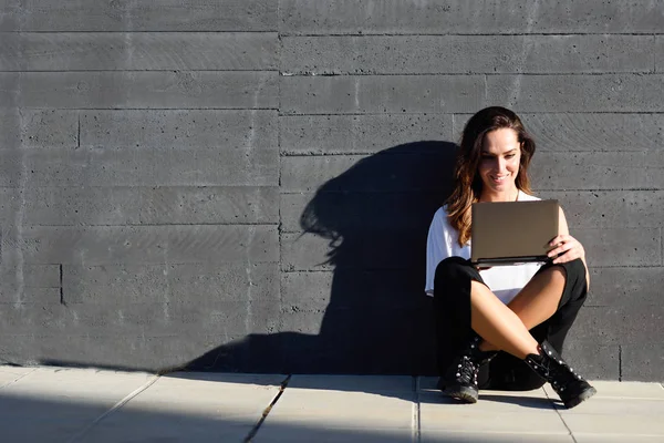 Junge Geschäftsfrau arbeitet mit ihrem Laptop auf dem Boden sitzend. — Stockfoto