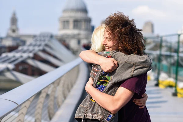 Lyckligt par kramar av Millennium Bridge, Themsen, London. — Stockfoto