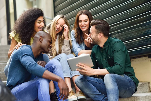 Gruppo multietnico di giovani che guardano un tablet — Foto Stock