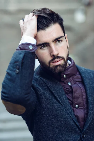 Jovem barbudo homem no urbano fundo vestindo britânico elegante terno no o rua . — Fotografia de Stock