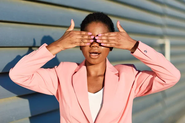 Engraçado mulher negra de pé na parede urbana cobrindo seus olhos com as mãos . — Fotografia de Stock