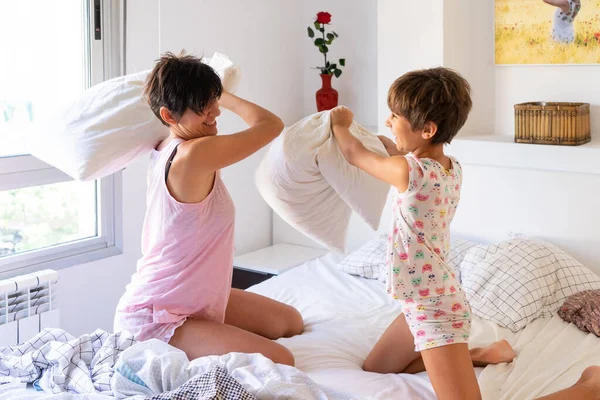 Mãe e filha tendo travesseiro engraçado luta na cama . — Fotografia de Stock