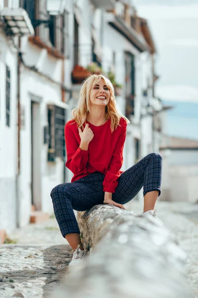 Blond meisje glimlachend met rode shirt genieten van het leven buitenshuis. — Stockfoto