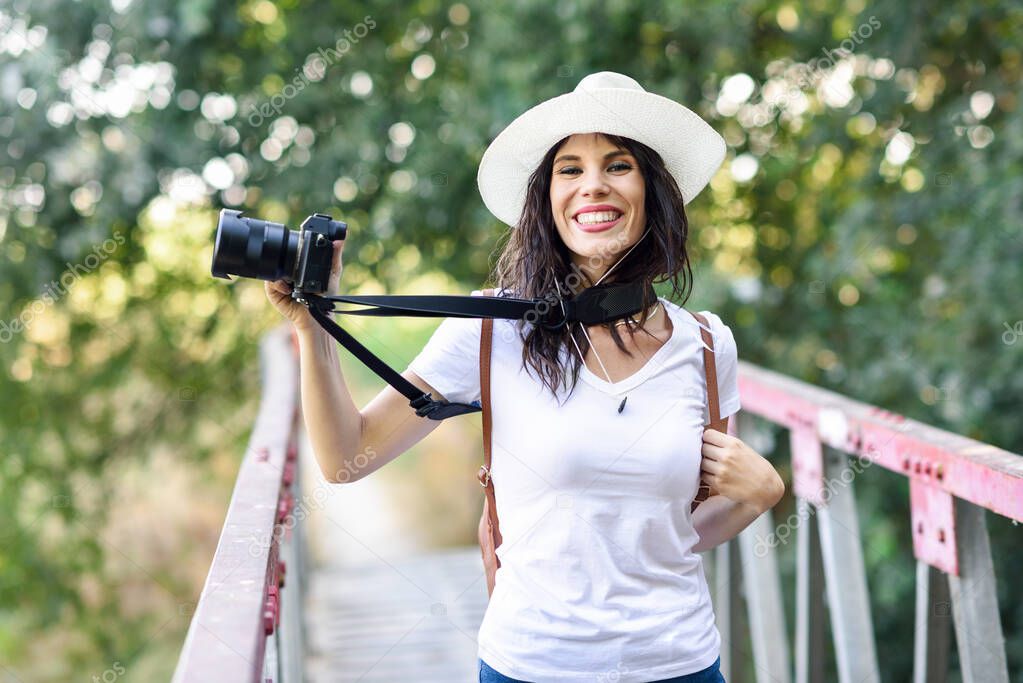 Hiker woman taking photographs with a mirrorless camera