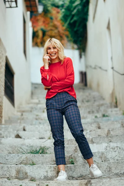 Feliz joven rubia riendo en hermosos escalones en la calle . — Foto de Stock