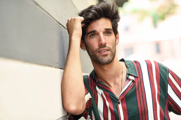 Atractivo joven con cabello oscuro y peinado moderno con ropa casual al aire libre — Foto de Stock