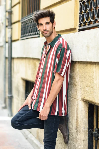 Attraente giovane uomo con i capelli scuri e acconciatura moderna che indossa abiti casual all'aperto — Foto Stock