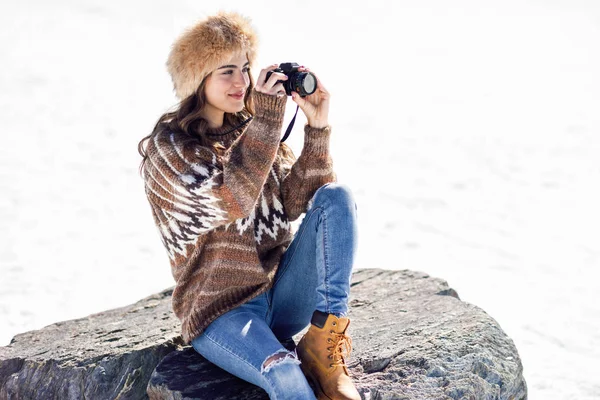 Mujer joven tomando fotografías en las montañas nevadas — Foto de Stock
