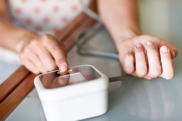 Donna che misura la propria pressione sanguigna a casa . — Foto Stock