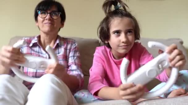 Mother and daughter playing car videogames at home — Stock Video