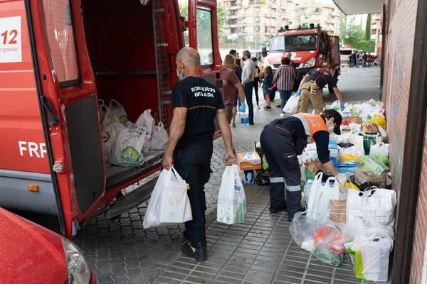 Пожарные собирают продовольствие и предметы первой необходимости для жертв нищеты от пандемии Ковид-19. — стоковое фото