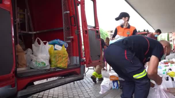 Hasiči sbírající potraviny a základní potřeby pro oběti chudoby z pandemie Covid-19. — Stock video