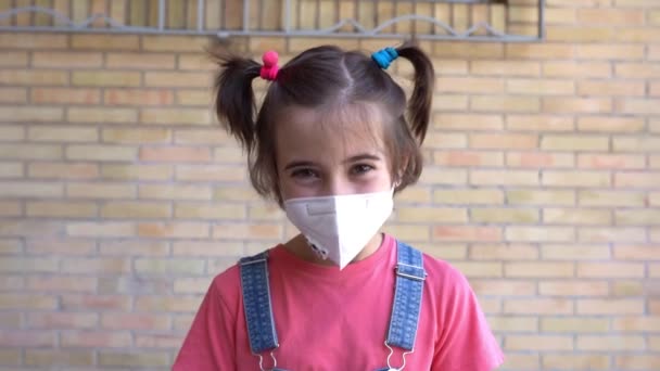 Kind meisje met een beschermmasker tegen coronavirus tijdens Covid-19 pandemie — Stockvideo