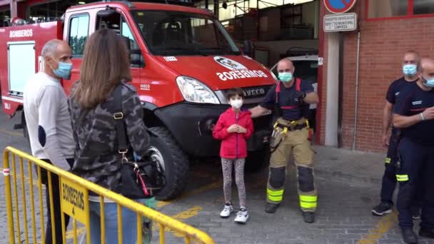 Mädchen fotografiert mit einem Feuerwehrmann bei der Nahrungsmittelsammlung für die Opfer der Covid-19-Pandemie. — Stockvideo
