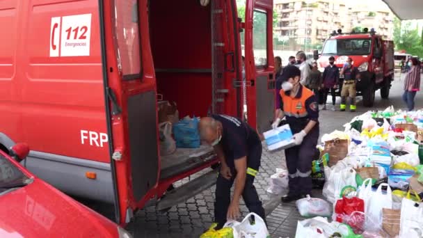 Brandweerlieden verzamelen voedsel en basisbehoeften voor de slachtoffers van armoede door de Covid-19 pandemie. — Stockvideo