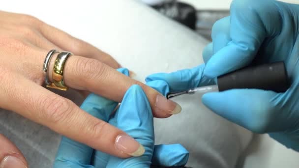 Manicure verft nagels met gel polijsten op klanten nagels. — Stockvideo