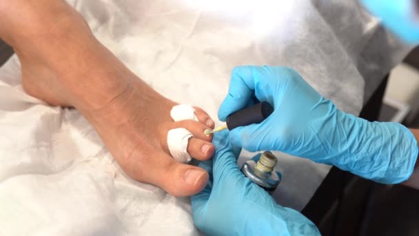 Kosmetička dává pedikúru malovat své klienty nehty v krásném centru. — Stock video