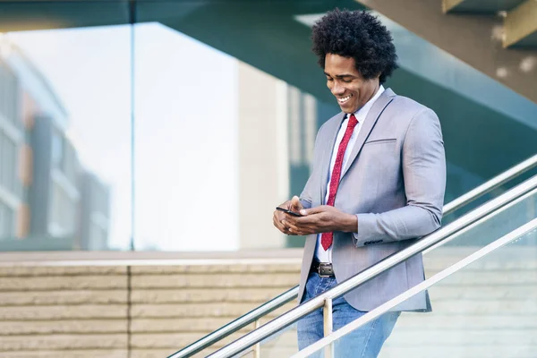 Black Businessman using a smartphone near an office building — Stock Photo, Image