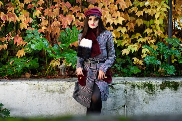 Menina bonita nova com cabelos muito longos usando casaco de inverno e boné no outono folhas fundo — Fotografia de Stock