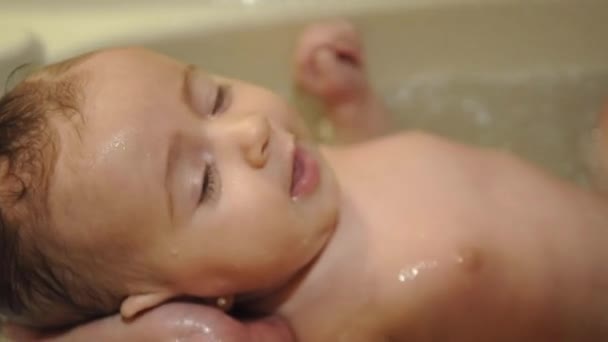 Padre bañando a su pequeño bebé en la bañera — Vídeo de stock