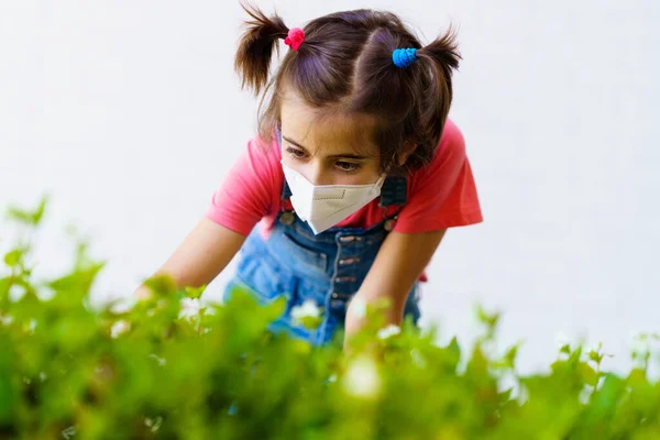 Девочка носит защитную маску против коронавируса во время пандемии Ковид-19 — стоковое фото