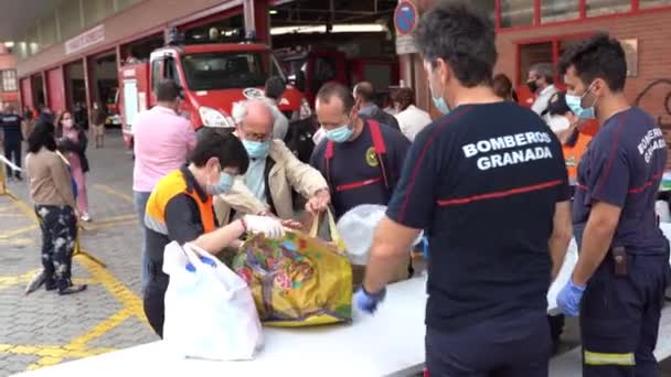 Пожарные собирают продовольствие и предметы первой необходимости для жертв нищеты от пандемии Ковид-19. — стоковое видео