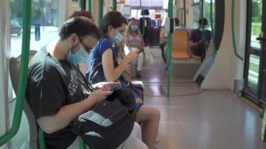 Metro vagonunda vurularak her istasyonda insanlara maske takarak.