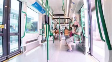 Metro vagonunda çekilen zaman çizelgesi her istasyonda insanlara maske takıyor.