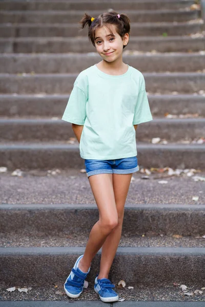 Menina de nove anos em pé nos degraus ao ar livre — Fotografia de Stock