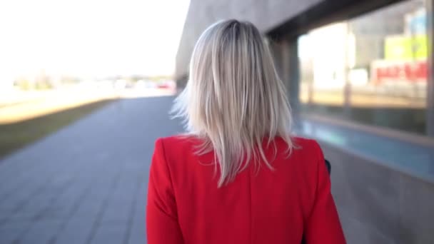 Geschäftsfrau mittleren Alters spaziert aus einem Bürogebäude. — Stockvideo