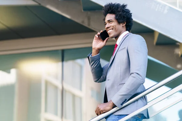 Black Businessman använder en smartphone nära en kontorsbyggnad — Stockfoto