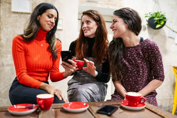 Grupa trzech szczęśliwych przyjaciół pijących kawę w kawiarni. — Zdjęcie stockowe