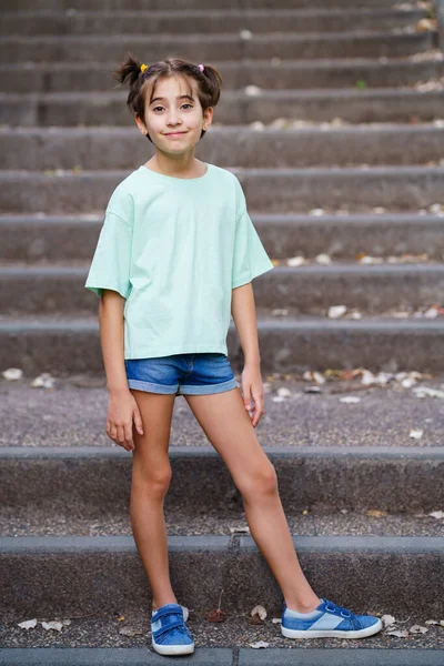 Menina de nove anos em pé nos degraus ao ar livre — Fotografia de Stock
