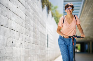Elektrikli scooter kullanan bir kadın.