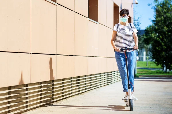 Frau fährt mit Elektroroller durch die Stadt — Stockfoto