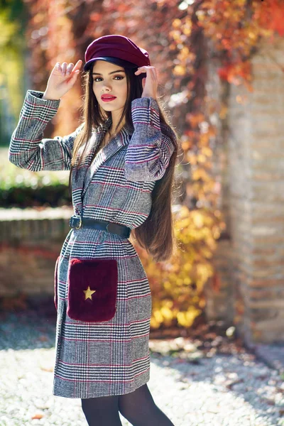 Menina bonita nova vestindo casaco de inverno e boné no outono folhas fundo. — Fotografia de Stock