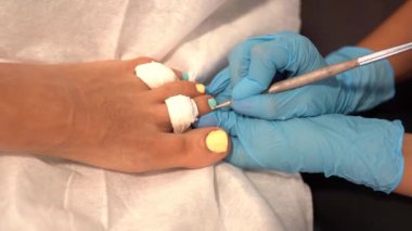 Güzellik uzmanı müşterilerine güzellik merkezinde tırnaklarını boyuyor..