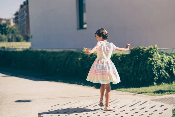 Felice ragazza di 9 anni in un bel vestito che gioca — Foto Stock
