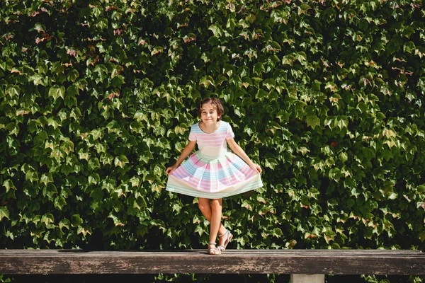 Happy 9-year-old girl in a pretty dress playing — Stock Photo, Image