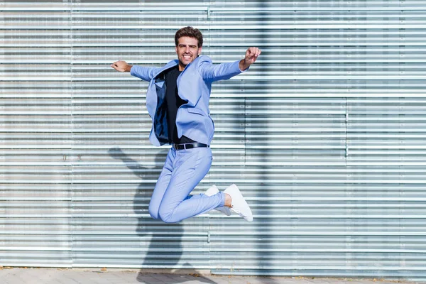 Молодий чоловік у костюмі стрибає на відкритому повітрі — стокове фото