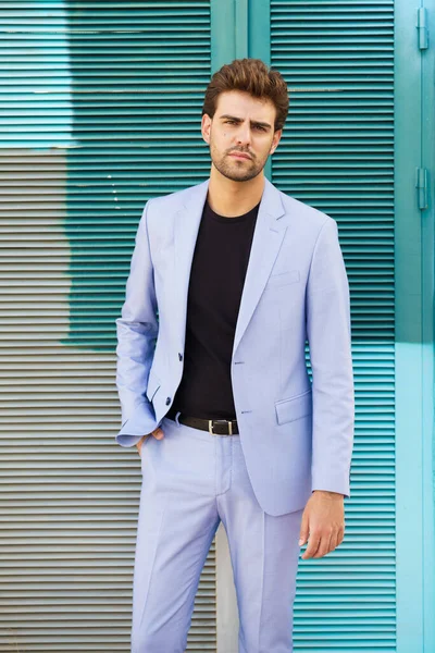 Hombre atractivo vistiendo traje de pie en el fondo urbano. —  Fotos de Stock