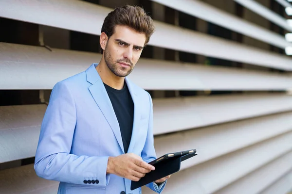 Homme d'affaires utilisant une tablette numérique près d'un immeuble de bureaux — Photo