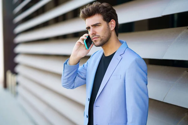 Бізнесмен розмовляє зі своїм смартфоном у синьому костюмі . — стокове фото
