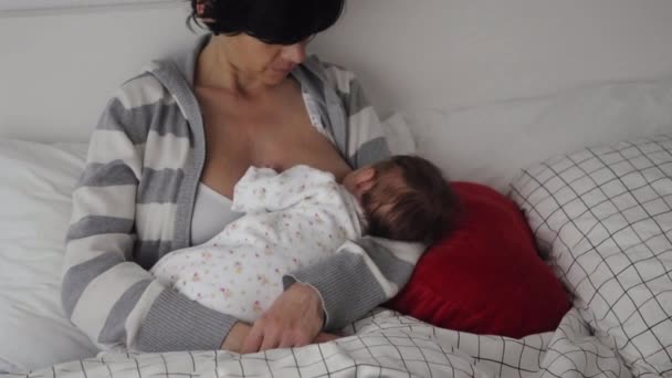 Mama caucaziană alăptează nou-născutul pe pat — Videoclip de stoc