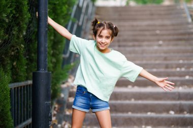 Dokuz yaşında bir kız sokak lambasıyla oynuyor.