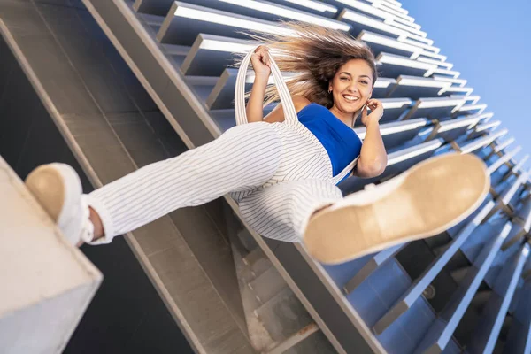 Vista desde abajo de la joven lanzando su pie en el aire. —  Fotos de Stock