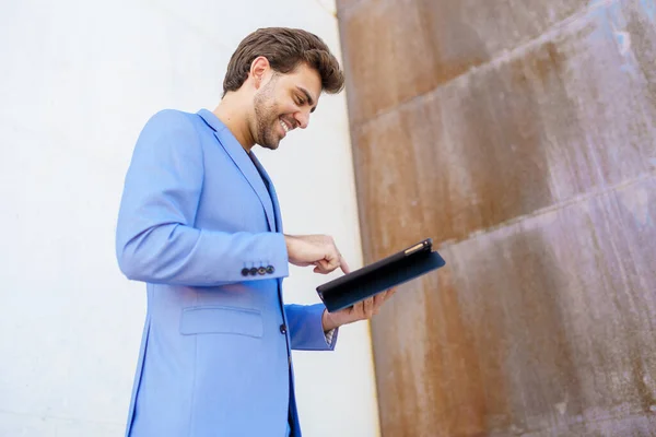 Zakenman met een digitale tablet in de buurt van een kantoorgebouw — Stockfoto