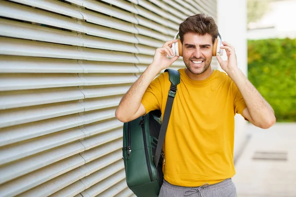 Jovem com fones de ouvido em fundo urbano — Fotografia de Stock